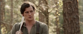 Movie still from “Abraham Lincoln: Vampire Hunter” (2012), directed by Timur Bekmambetov – A young man with long brown hair wearing a green shirt and suspenders in a wooded area; Close Up shot, Over the shoulder angle