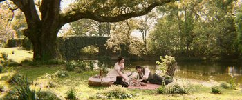 Movie still from “Abraham Lincoln: Vampire Hunter” (2012), directed by Timur Bekmambetov – A man and a woman sitting on the grass near a body of water; Wide shot, High angle