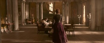Movie still from “Abraham Lincoln: Vampire Hunter” (2012), directed by Timur Bekmambetov – A woman standing in front of a man sitting at a dining table; Wide shot, High angle