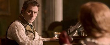 Movie still from “Abraham Lincoln: Vampire Hunter” (2012), directed by Timur Bekmambetov – A man sitting at a table in front of an open book; Medium shot, Over the shoulder angle
