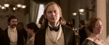 Movie still from “Abraham Lincoln: Vampire Hunter” (2012), directed by Timur Bekmambetov – A man with long blonde hair wearing a suit and bow tie; Close Up shot, Low angle