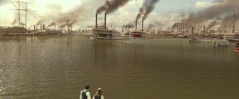 Movie still from “Abraham Lincoln: Vampire Hunter” (2012), directed by Timur Bekmambetov – Two people standing in front of a body of water with smoke billowing out of the stacks; Extreme Wide shot, High angle
