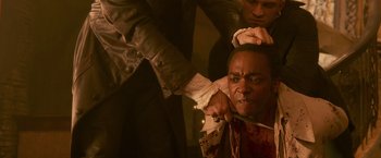 A man getting his head shaved by another man