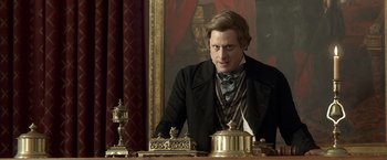 Movie still from “Abraham Lincoln: Vampire Hunter” (2012), directed by Timur Bekmambetov – A man sitting at a table in front of a painting; Close Up shot, Over the shoulder angle