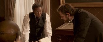Movie still from “Abraham Lincoln: Vampire Hunter” (2012), directed by Timur Bekmambetov – A man and a woman looking at a book; Medium shot, Over the shoulder angle