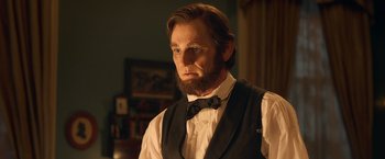 Movie still from “Abraham Lincoln: Vampire Hunter” (2012), directed by Timur Bekmambetov – A man with a beard wearing a vest and a bow tie; Close Up shot, Over the shoulder angle
