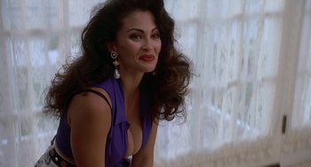 Movie still from “Ace Ventura: Pet Detective” (1994), directed by Tom Shadyac – A woman in a purple dress sitting in front of a window; Close Up shot, Low angle