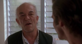 Movie still from “Ace Ventura: Pet Detective” (1994), directed by Tom Shadyac – An older man talking to a younger man in front of a window; Close Up shot, Over the shoulder angle