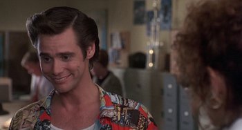 Movie still from “Ace Ventura: Pet Detective” (1994), directed by Tom Shadyac – A person wearing a colorful shirt; Close Up shot, Over the shoulder angle