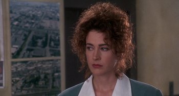 Movie still from “Ace Ventura: Pet Detective” (1994), directed by Tom Shadyac – A person wearing a suit and tie; Close Up shot, Over the shoulder angle