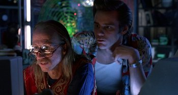Movie still from “Ace Ventura: Pet Detective” (1994), directed by Tom Shadyac – Two men sitting next to each other in a room; Close Up shot, Low angle