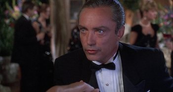 Movie still from “Ace Ventura: Pet Detective” (1994), directed by Tom Shadyac – A person wearing a suit and a bow tie; Close Up shot, Over the shoulder angle