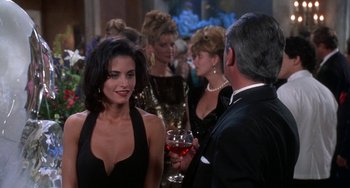 Movie still from “Ace Ventura: Pet Detective” (1994), directed by Tom Shadyac – A group of people standing in a room with wine glasses; Medium shot, Over the shoulder angle