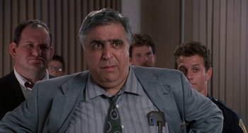 Movie still from “Ace Ventura: Pet Detective” (1994), directed by Tom Shadyac – A person wearing a suit and a tie; Close Up shot, Over the shoulder angle