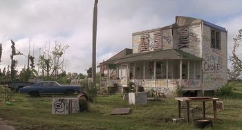 Movie still from “Ace Ventura: Pet Detective” (1994), directed by Tom Shadyac – An abandoned house with graffiti on the walls; Extreme Wide shot, Low angle