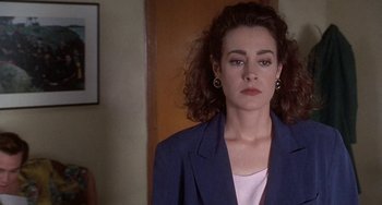 Movie still from “Ace Ventura: Pet Detective” (1994), directed by Tom Shadyac – A person wearing a suit jacket; Close Up shot, Over the shoulder angle