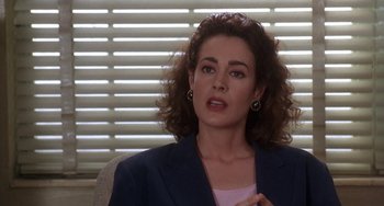 Movie still from “Ace Ventura: Pet Detective” (1994), directed by Tom Shadyac – A person sitting in a chair wearing a suit; Close Up shot, Over the shoulder angle