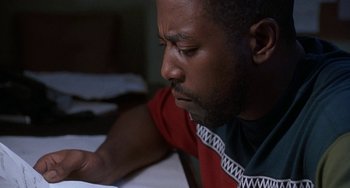 Movie still from “Ace Ventura: Pet Detective” (1994), directed by Tom Shadyac – A person looking down at a paper; Close Up shot, Low angle