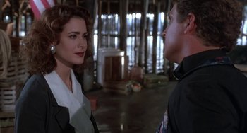 Movie still from “Ace Ventura: Pet Detective” (1994), directed by Tom Shadyac – A man and a woman are talking in a room; Medium shot, Over the shoulder angle