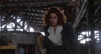 Movie still from “Ace Ventura: Pet Detective” (1994), directed by Tom Shadyac – A woman in a black suit and white shirt; Medium shot, Low angle