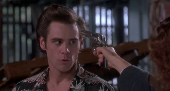 Movie still from “Ace Ventura: Pet Detective” (1994), directed by Tom Shadyac – A man is holding a gun up to his head; Close Up shot, Over the shoulder angle