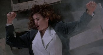 Movie still from “Ace Ventura: Pet Detective” (1994), directed by Tom Shadyac – A woman in a white coat is holding her arms up; Medium shot, Low angle