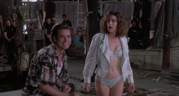 Movie still from “Ace Ventura: Pet Detective” (1994), directed by Tom Shadyac – A man and a woman in white lingerie; Medium shot, Over the shoulder angle