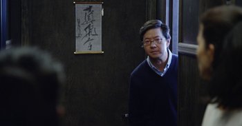A man standing in front of a wooden wall