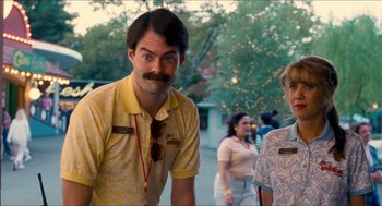Movie still from “Adventureland” (2009), directed by Greg Mottola – A man in a yellow shirt standing next to a woman in a yellow shirt; Medium shot, Over the shoulder angle