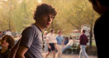 Movie still from “Adventureland” (2009), directed by Greg Mottola – A man standing in front of a group of people; Medium shot, Over the shoulder angle
