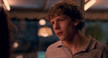 Movie still from “Adventureland” (2009), directed by Greg Mottola – A man with curly brown hair looking to his left; Close Up shot, Over the shoulder angle