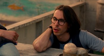 Movie still from “Adventureland” (2009), directed by Greg Mottola – A man with glasses is leaning on a ledge; Close Up shot, Over the shoulder angle