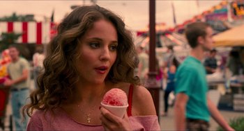 Movie still from “Adventureland” (2009), directed by Greg Mottola – A woman holding an ice cream cone while standing on a sidewalk; Close Up shot, Over the shoulder angle