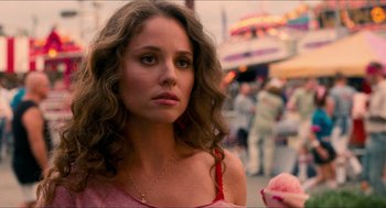 Movie still from “Adventureland” (2009), directed by Greg Mottola – A beautiful young woman in a pink dress; Close Up shot, Over the shoulder angle