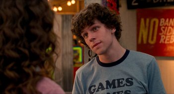 Movie still from “Adventureland” (2009), directed by Greg Mottola – A man with curly hair and a shirt that says " games games games " on it; Close Up shot, Over the shoulder angle