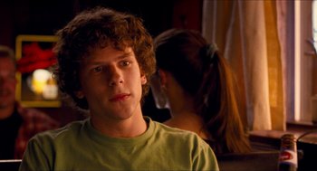 Movie still from “Adventureland” (2009), directed by Greg Mottola – A man and a woman are looking at the camera; Close Up shot, Over the shoulder angle