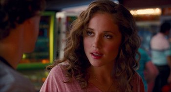 Movie still from “Adventureland” (2009), directed by Greg Mottola – A beautiful young woman with long brown curly hair; Close Up shot, Over the shoulder angle