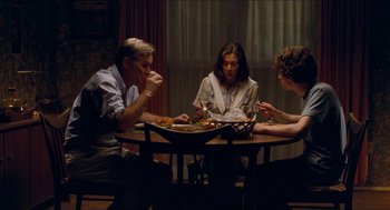 Movie still from “Adventureland” (2009), directed by Greg Mottola – A group of people sitting around a table eating food; Medium shot, High angle