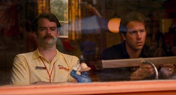 Movie still from “Adventureland” (2009), directed by Greg Mottola – Two men sitting at a table in front of each other; Medium shot, Over the shoulder angle