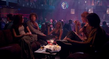 Movie still from “Adventureland” (2009), directed by Greg Mottola – A group of people sitting around a room; Wide shot, High angle