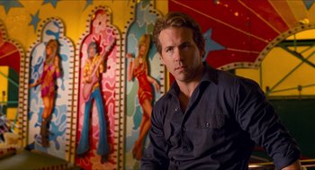 Movie still from “Adventureland” (2009), directed by Greg Mottola – A man sitting in front of a painting of a woman; Close Up shot, Low angle