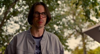 Movie still from “Adventureland” (2009), directed by Greg Mottola – A man wearing glasses standing in front of a tree; Close Up shot, Over the shoulder angle