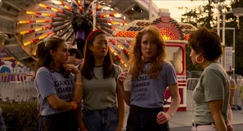 Movie still from “Adventureland” (2009), directed by Greg Mottola – Three women standing next to each other at a carnival; Medium shot, Over the shoulder angle