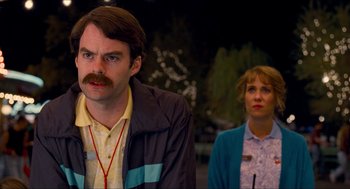 Movie still from “Adventureland” (2009), directed by Greg Mottola – A man and a woman standing next to each other; Close Up shot, Over the shoulder angle