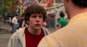 Movie still from “Adventureland” (2009), directed by Greg Mottola – A man with curly hair is looking at the camera; Close Up shot, Over the shoulder angle