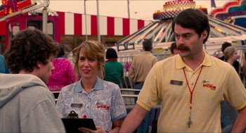 Movie still from “Adventureland” (2009), directed by Greg Mottola – A man and a woman standing next to each other at an amusement park; Medium shot, Over the shoulder angle
