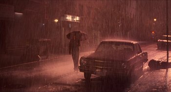 Movie still from “Adventureland” (2009), directed by Greg Mottola – A person walking in the rain with an umbrella; Extreme Wide shot, High angle