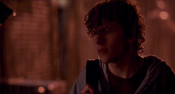 Movie still from “Adventureland” (2009), directed by Greg Mottola – A young man holding a cell phone in his hand; Close Up shot, Over the shoulder angle