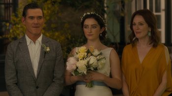 Movie still from “After the Wedding” (2019), directed by Bart Freundlich – A woman holding a bouquet of flowers in front of two men; Medium shot, Over the shoulder angle