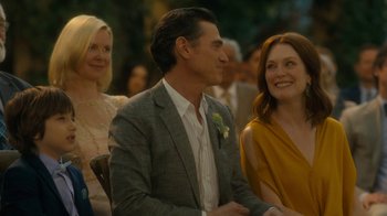 Movie still from “After the Wedding” (2019), directed by Bart Freundlich – A man and a woman sitting next to each other at an event; Close Up shot, Over the shoulder angle